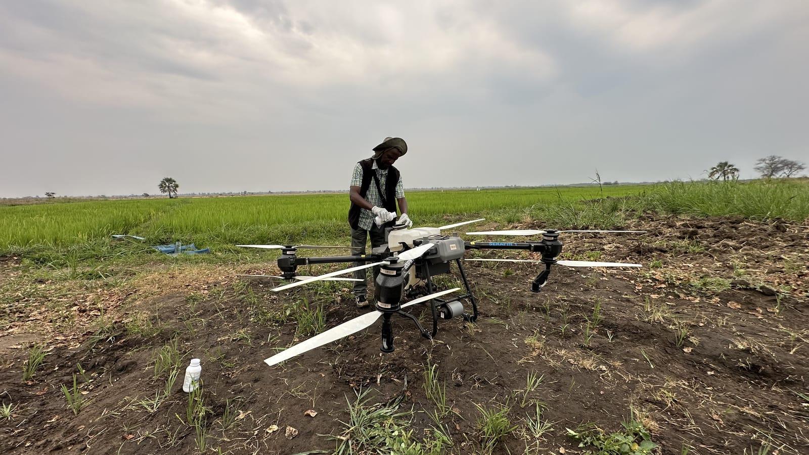 Pilot filling the spray tank next to a rice field in Salima